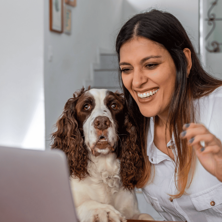 A woman and her dog sit at a desk